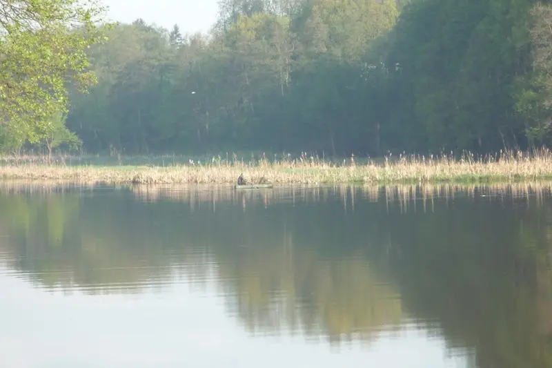 Вытаскивает край сети из воды