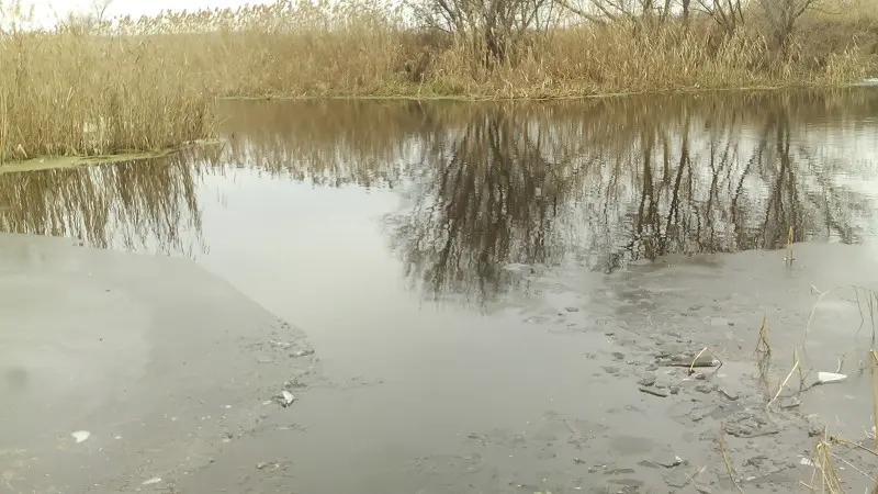 Пробивая палкой лед парни выплыли на лодках.